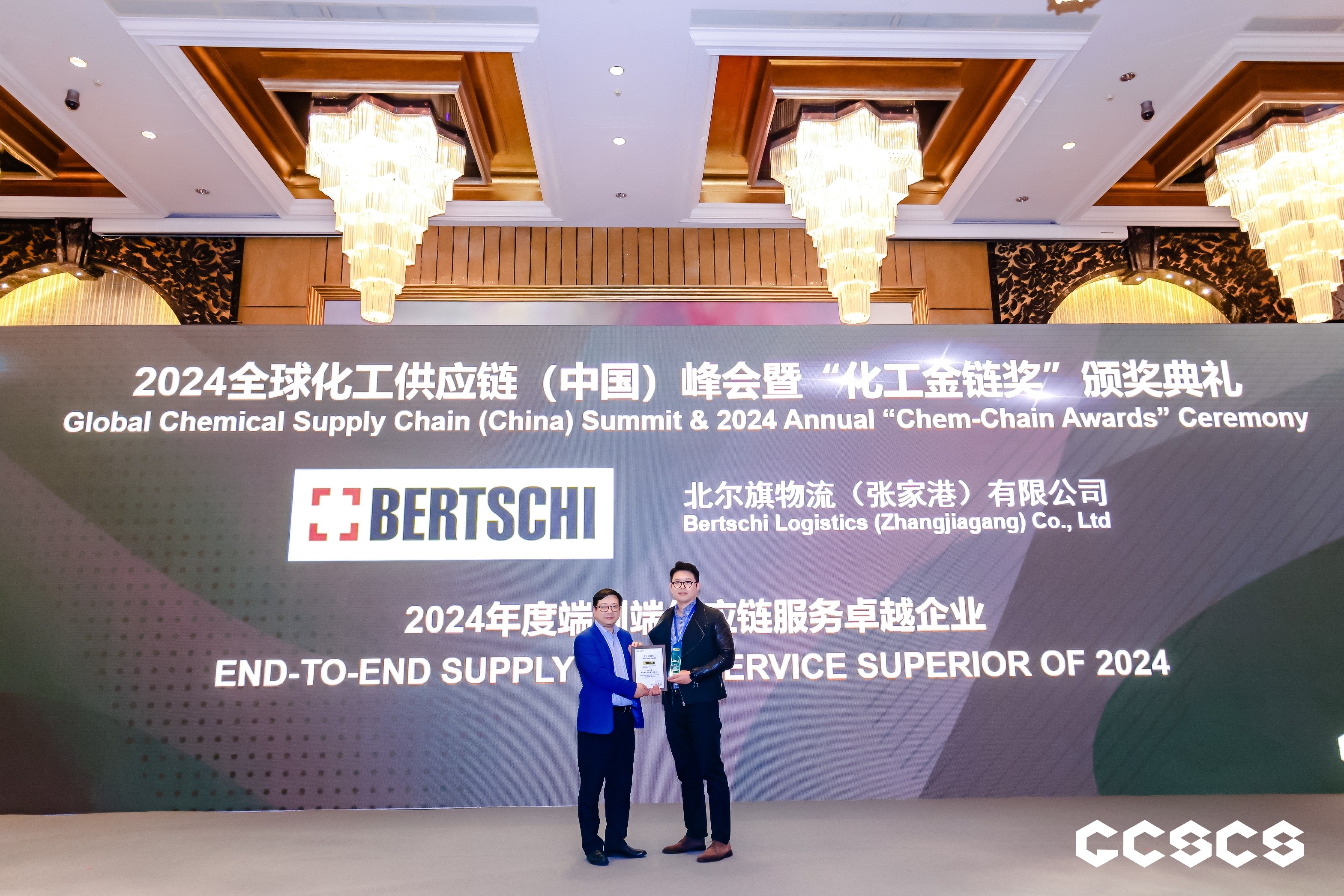 two people on stage accepting award