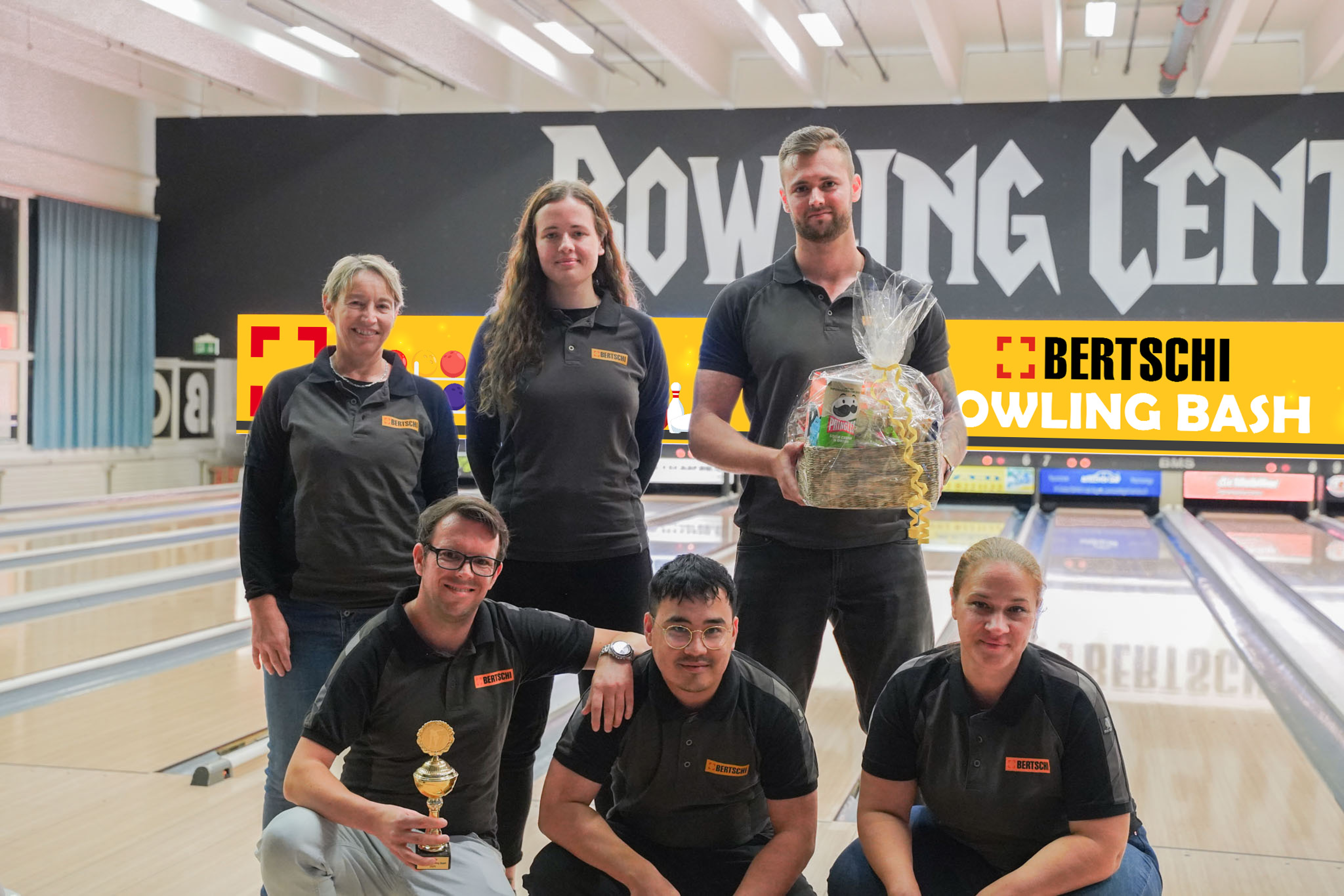 Die Gruppe aus 6 Bertschi Mitarbeitenden mit ihrem Pokal und ihrem Preis vor der Bowlingbahn