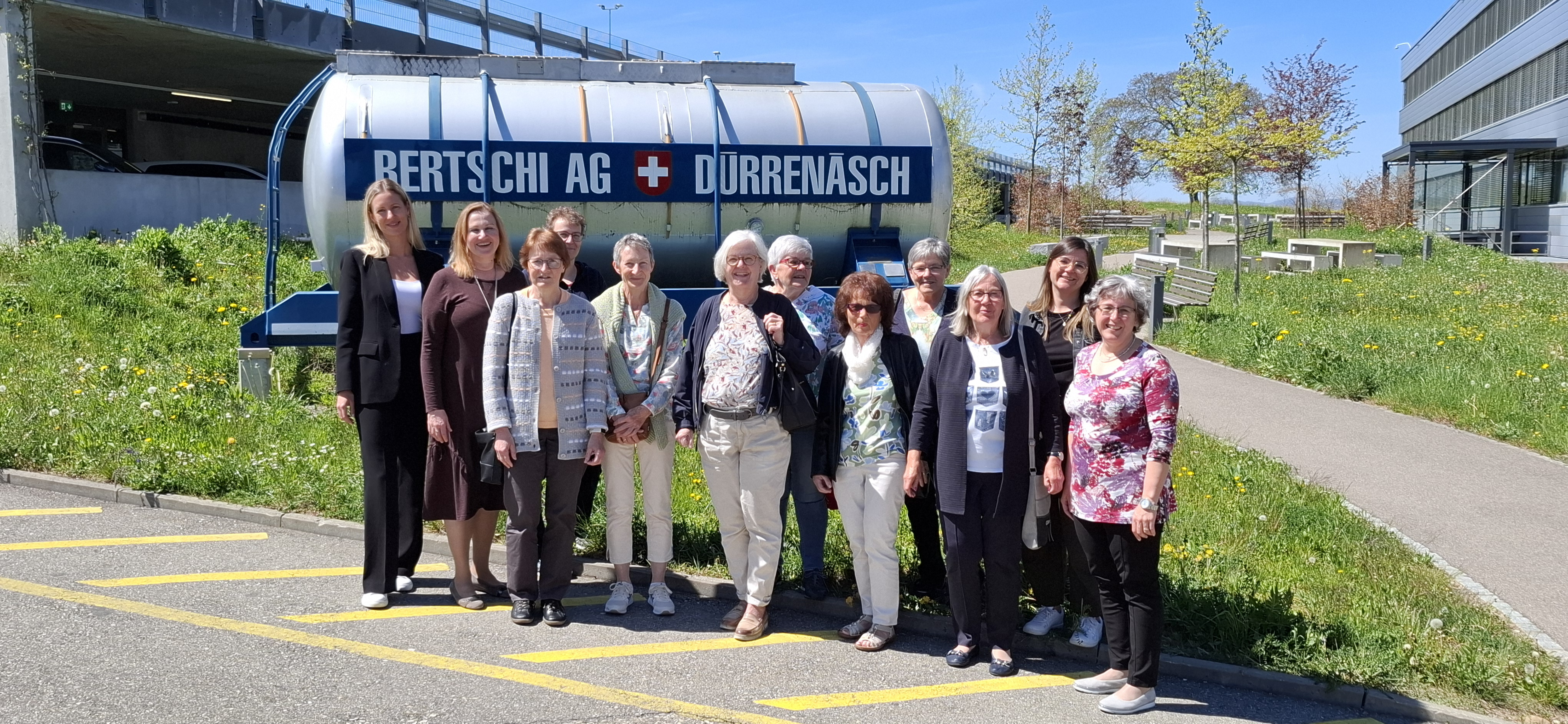 Retired Bertschi employees standing in a group photo in front of the historical Bertschi container at Headquarters