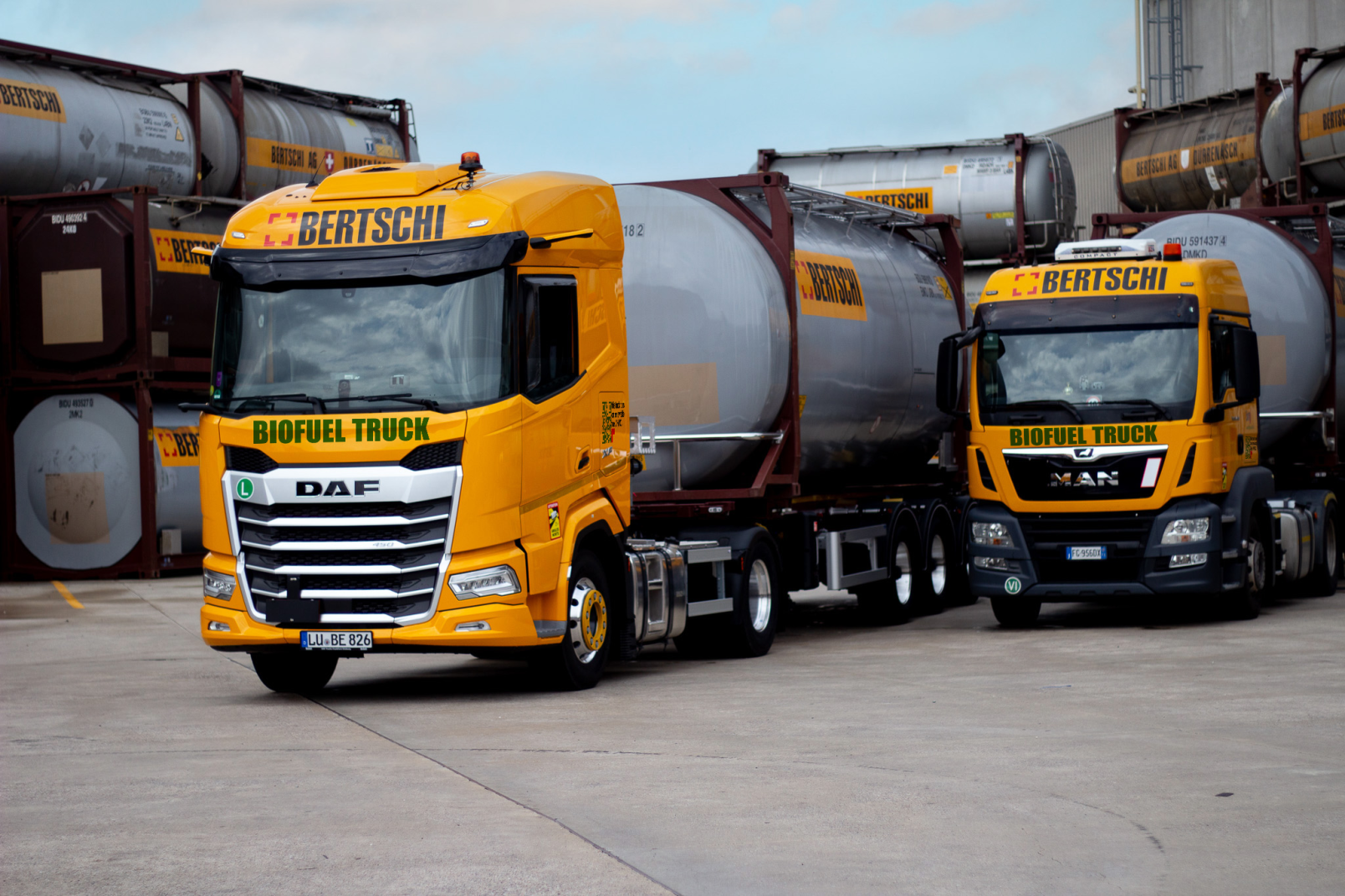 Two Bertschi trucks that run on biofuels, carrying a liquids tank container.
