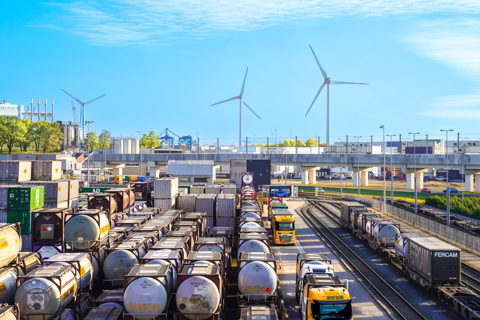 Container storage and rail logistics at Bertschi Rotterdam terminal with wind turbines in the background