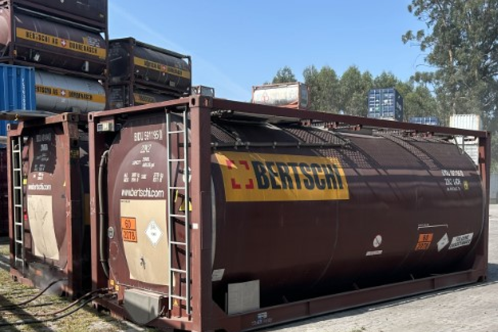 A container in the front and some Containers stacked on top of each other in the background