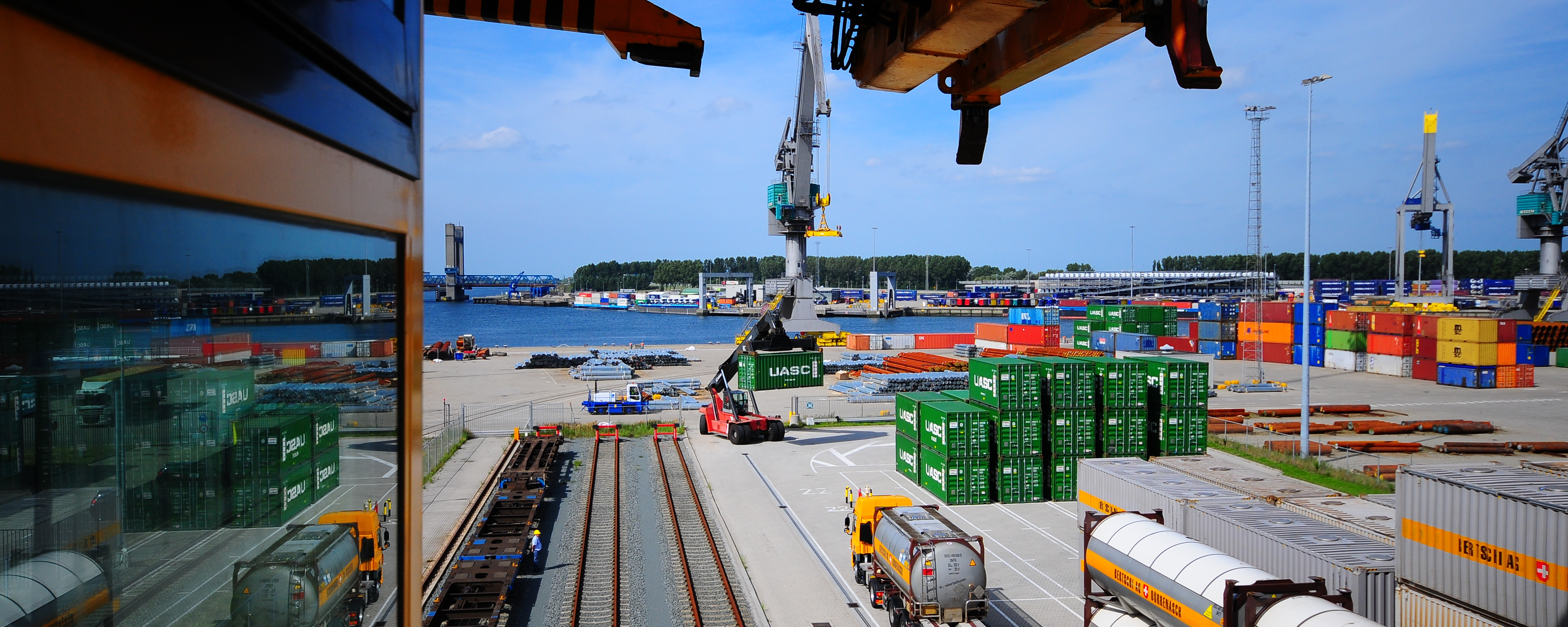 Bertschi port-side terminal with trucks, containers, and rail tracks