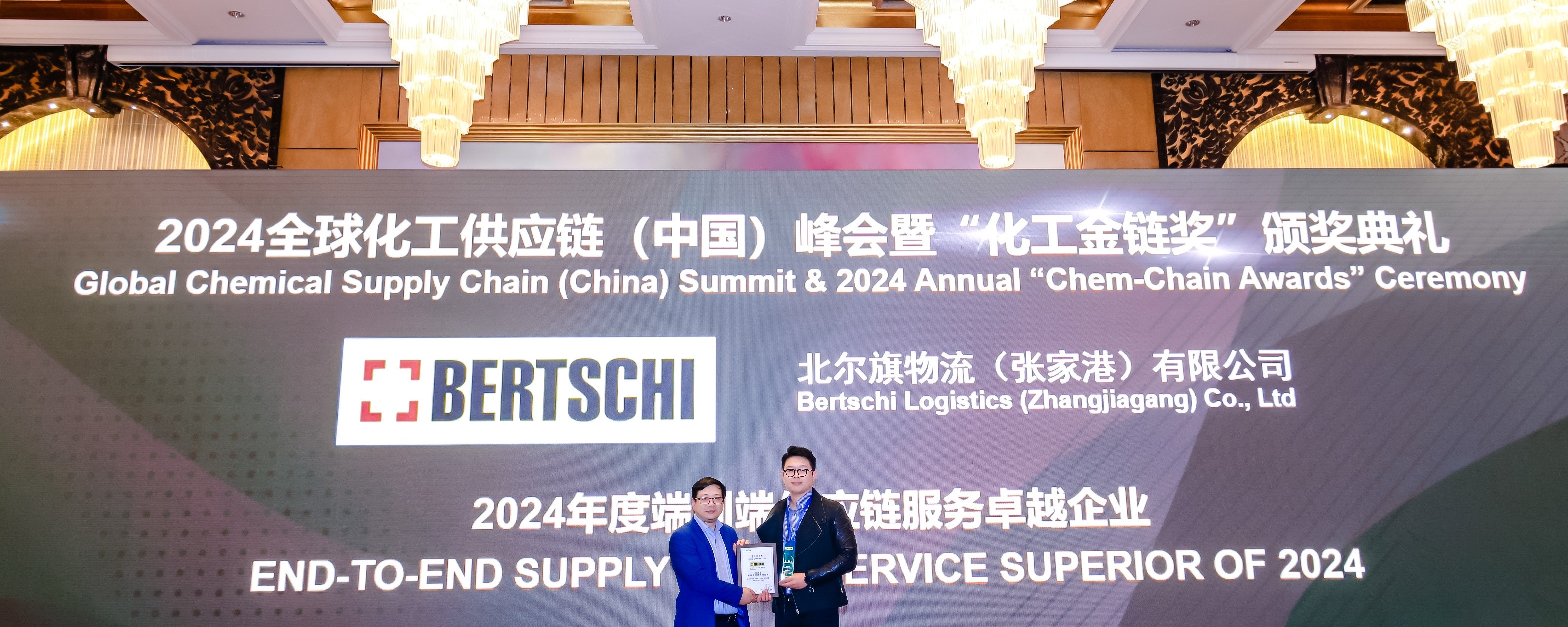 two people on stage accepting award