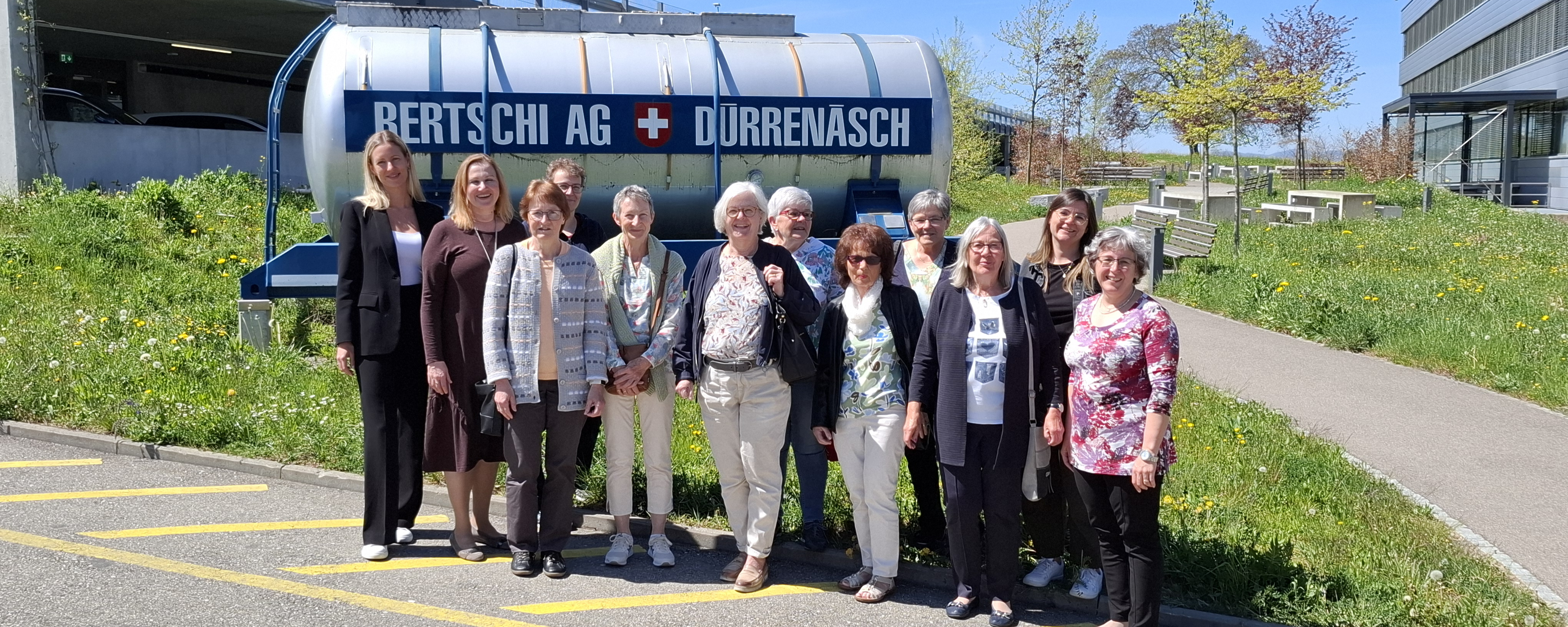 Retired Bertschi employees standing in a group photo in front of the historical Bertschi container at Headquarters